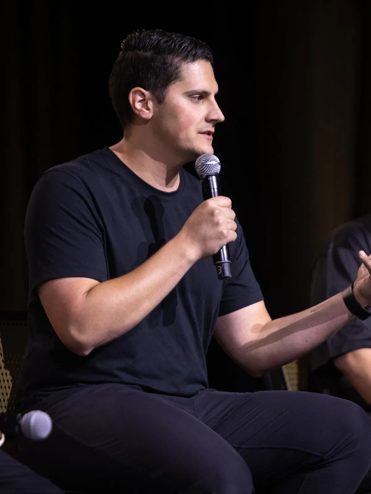 Carlo Orlando speaking into a microphone during a leadership panel